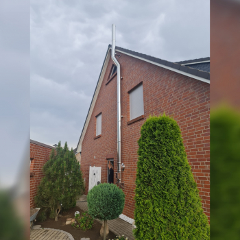 Kaminrohr hoch Edelstahl an Backsteinfassade