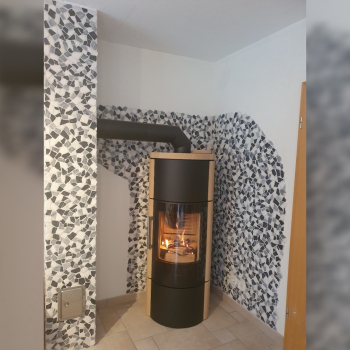 Kamin in Zimmer vor schwarzweiß marmorierten Fliesen