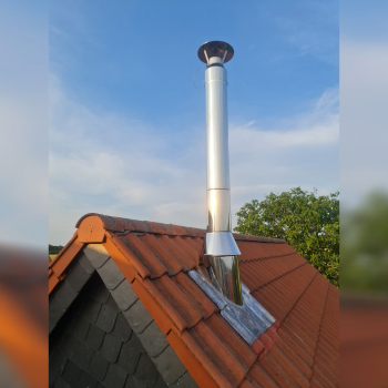 Edelstahl-Kaminrohr auf rot eingedecktem Satteldach