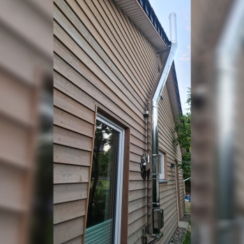 Kaminrohr Edelstahl seitlich an Haus mit Holzfassade